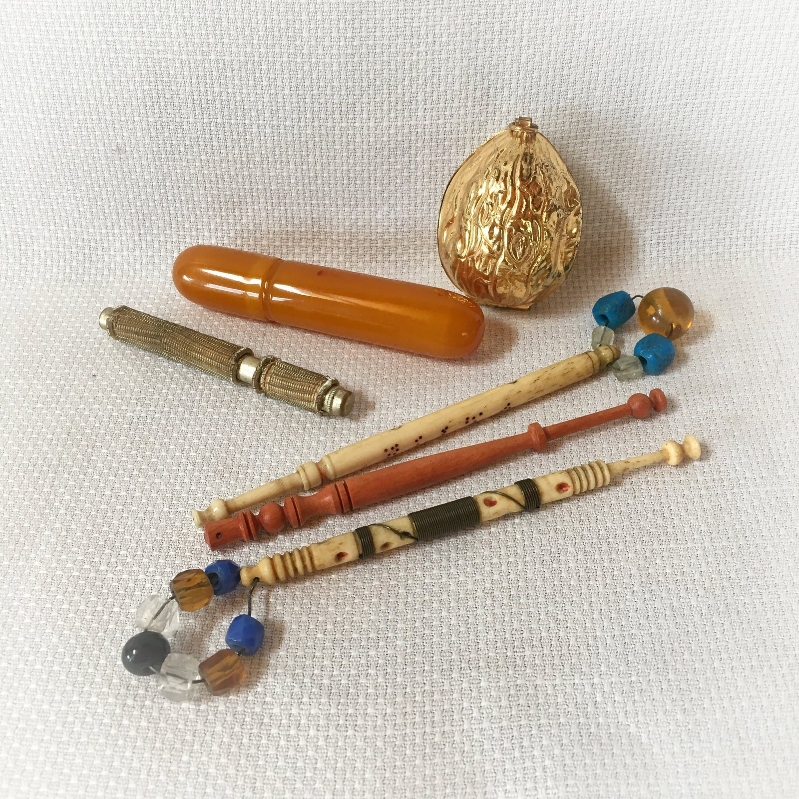 Group of Sewing Items: Bone Lace Bobbins, Bakelite Needle Case, Gold Tone Walnut Sewing Kit